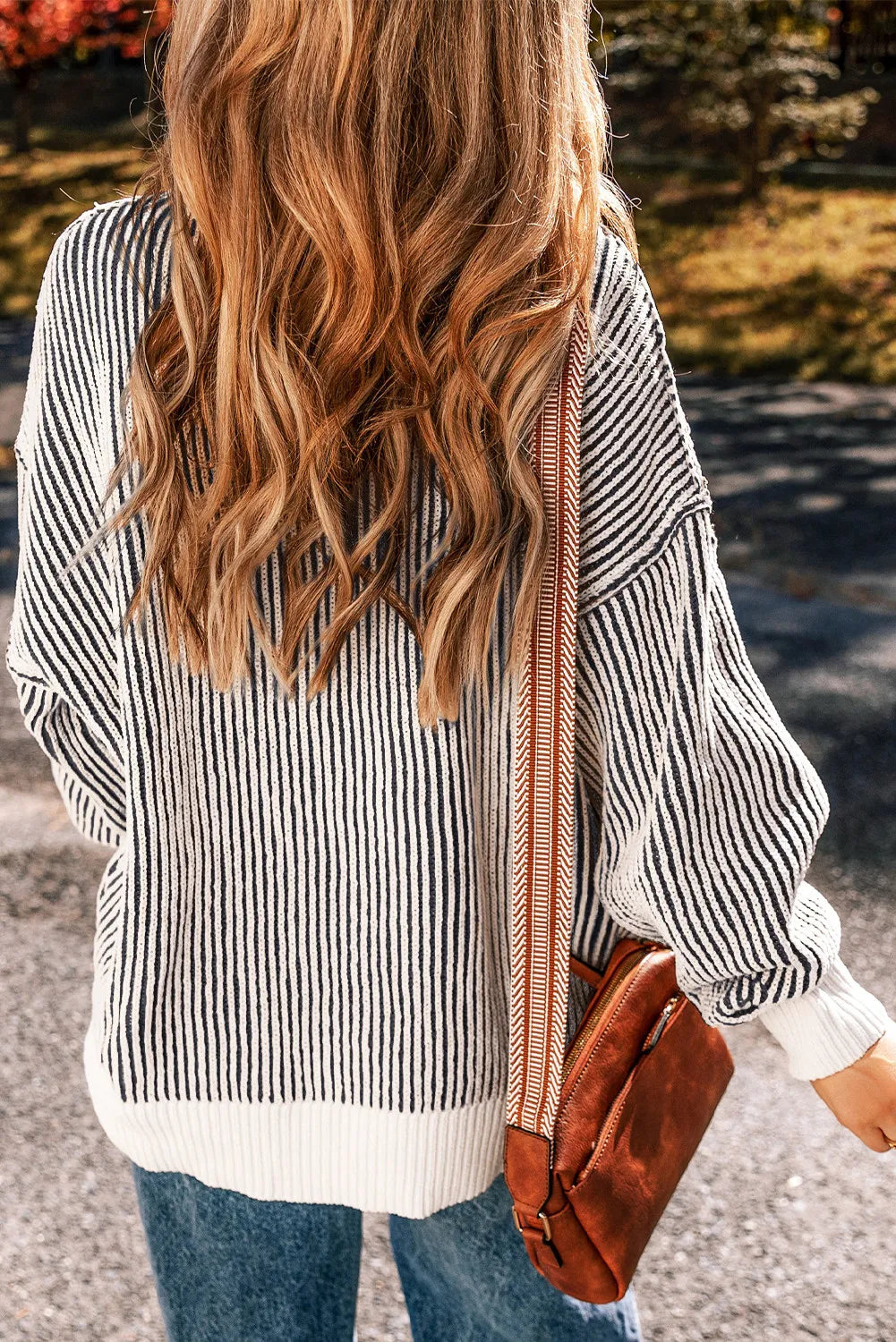 Black and white striped drop-shoulder knit sweater with ribbed hem and cuffs.