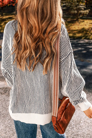 Black and white striped drop-shoulder knit sweater with ribbed hem and cuffs.