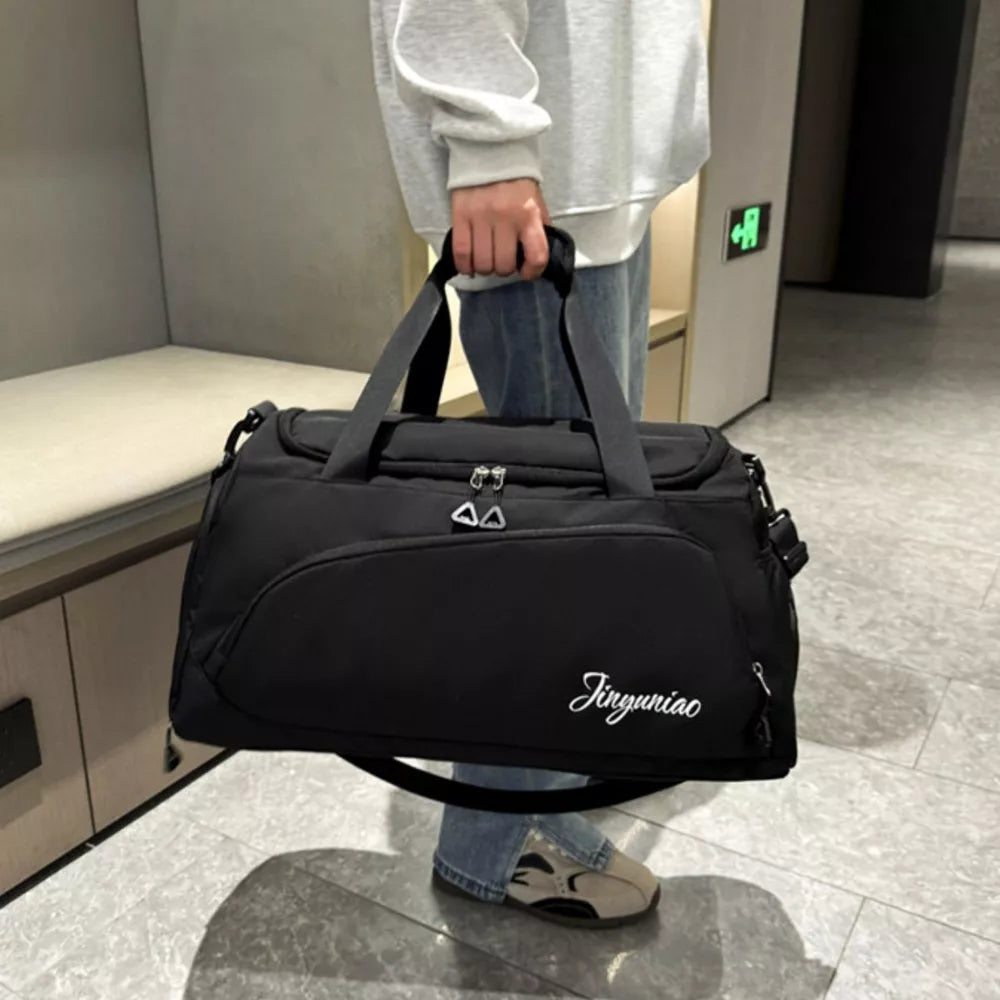 Black waterproof duffel bag with multiple pockets and white script logo detail.