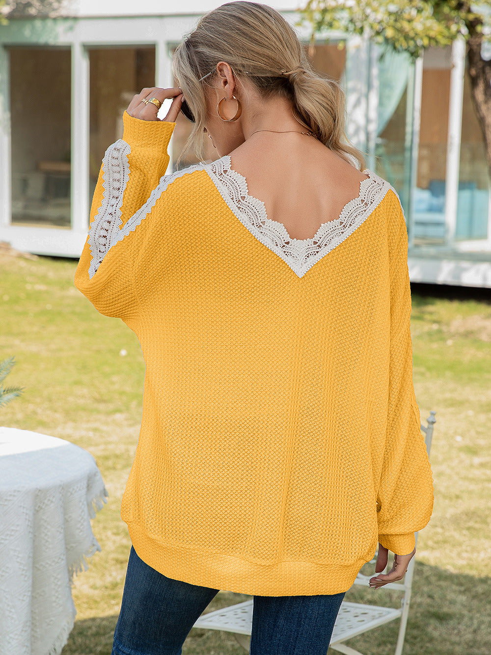Yellow waffle knit v-neck top with white lace trim on neckline and sleeves.