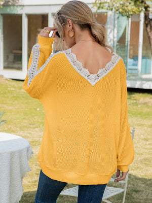 Yellow waffle knit v-neck top with white lace trim on neckline and sleeves.