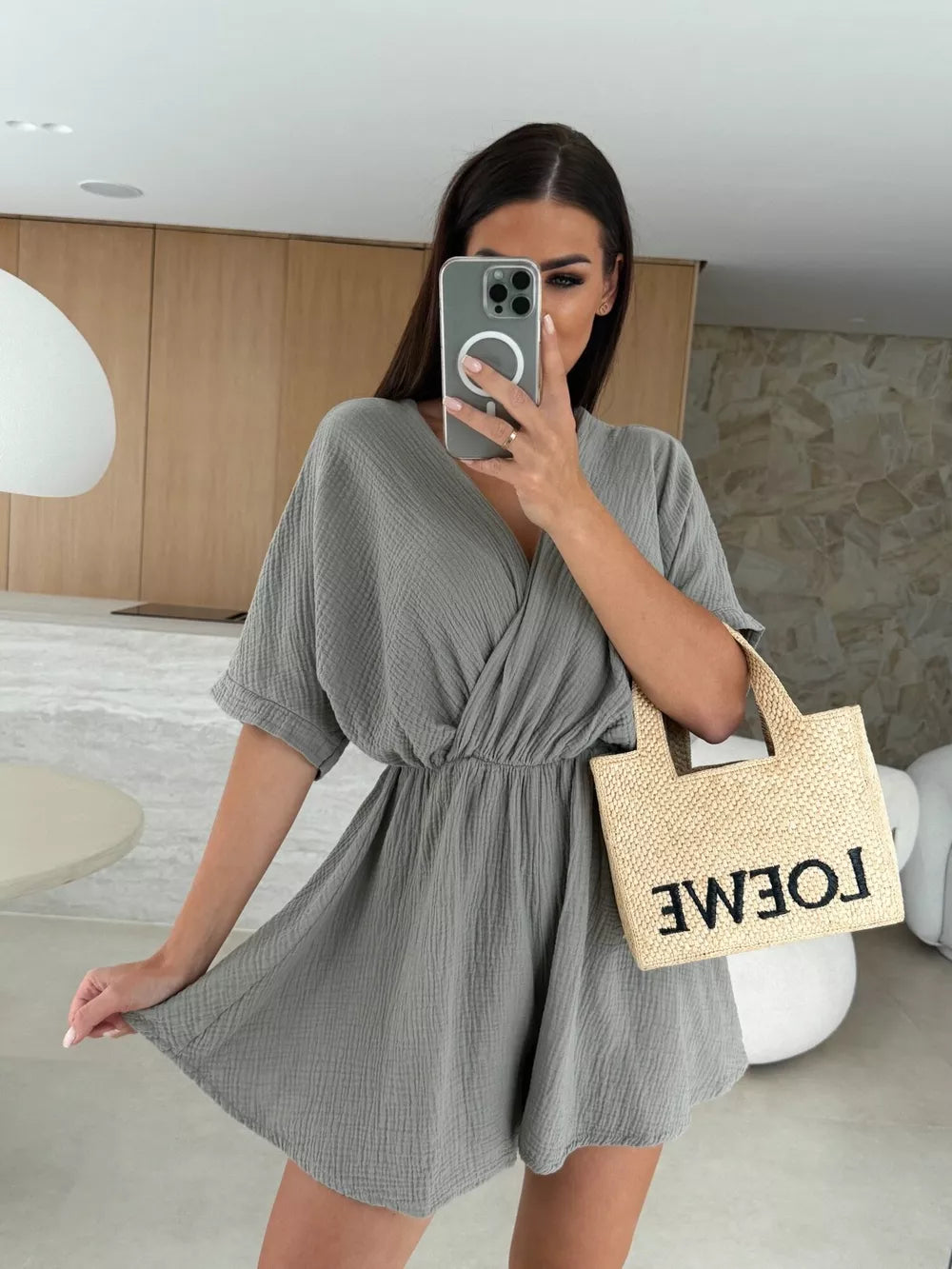 Dark gray twist-detail V-neck romper with cinched waist and dolman sleeves.