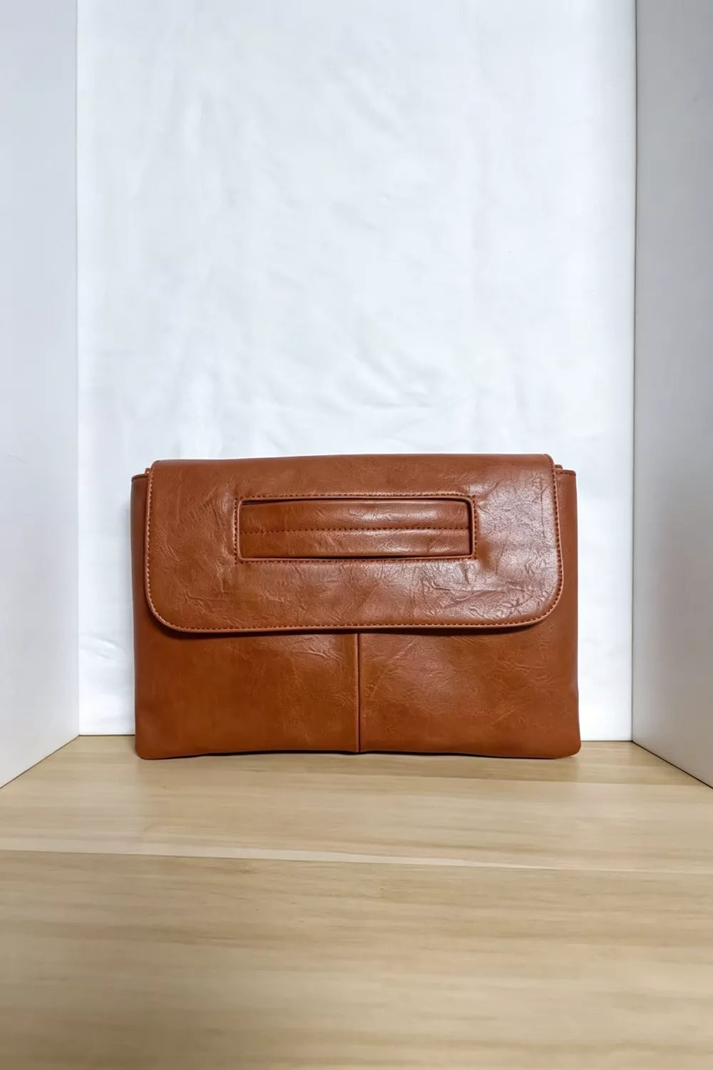 Brown distressed leather envelope clutch with cut-out handle detail