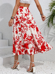 Crimson floral tiered midi skirt with ruffled hem, worn with white sandals.