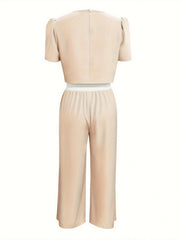 Beige cropped puff-sleeve top with white waistband and matching wide-leg pants.