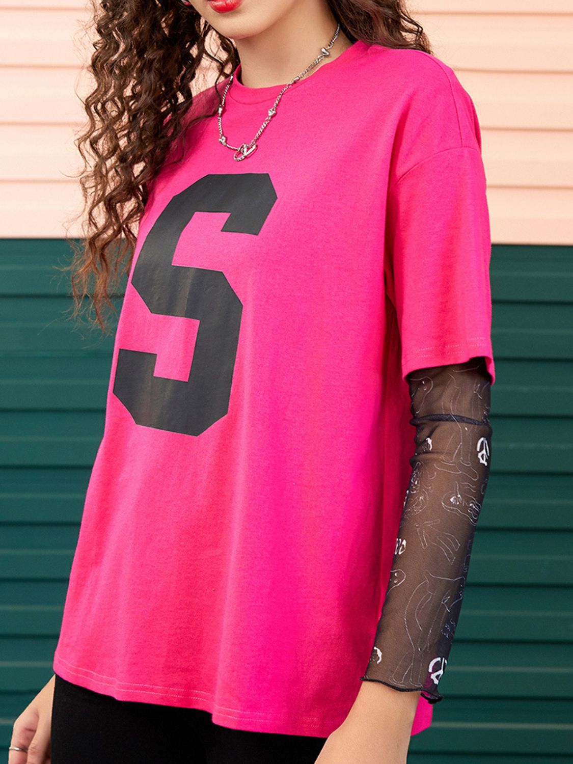 Hot pink t-shirt with large black number 5 and sheer mesh sleeves with graphic print.