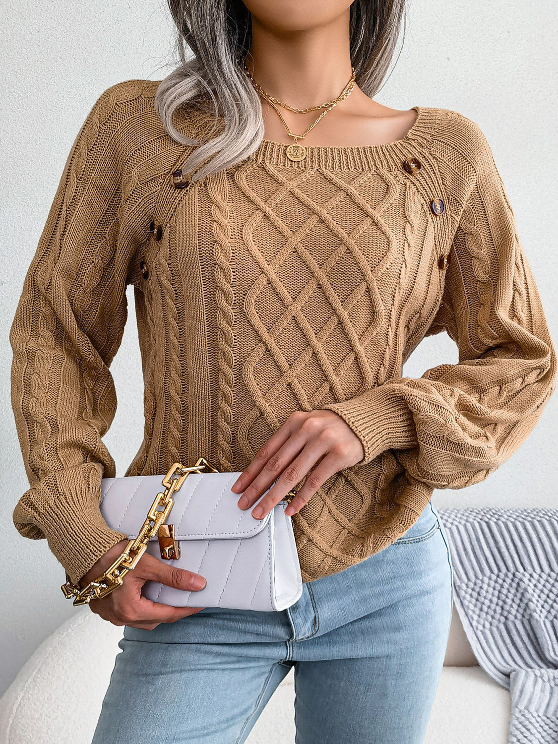 Khaki cable-knit sweater with buttoned shoulder detail and square neckline.