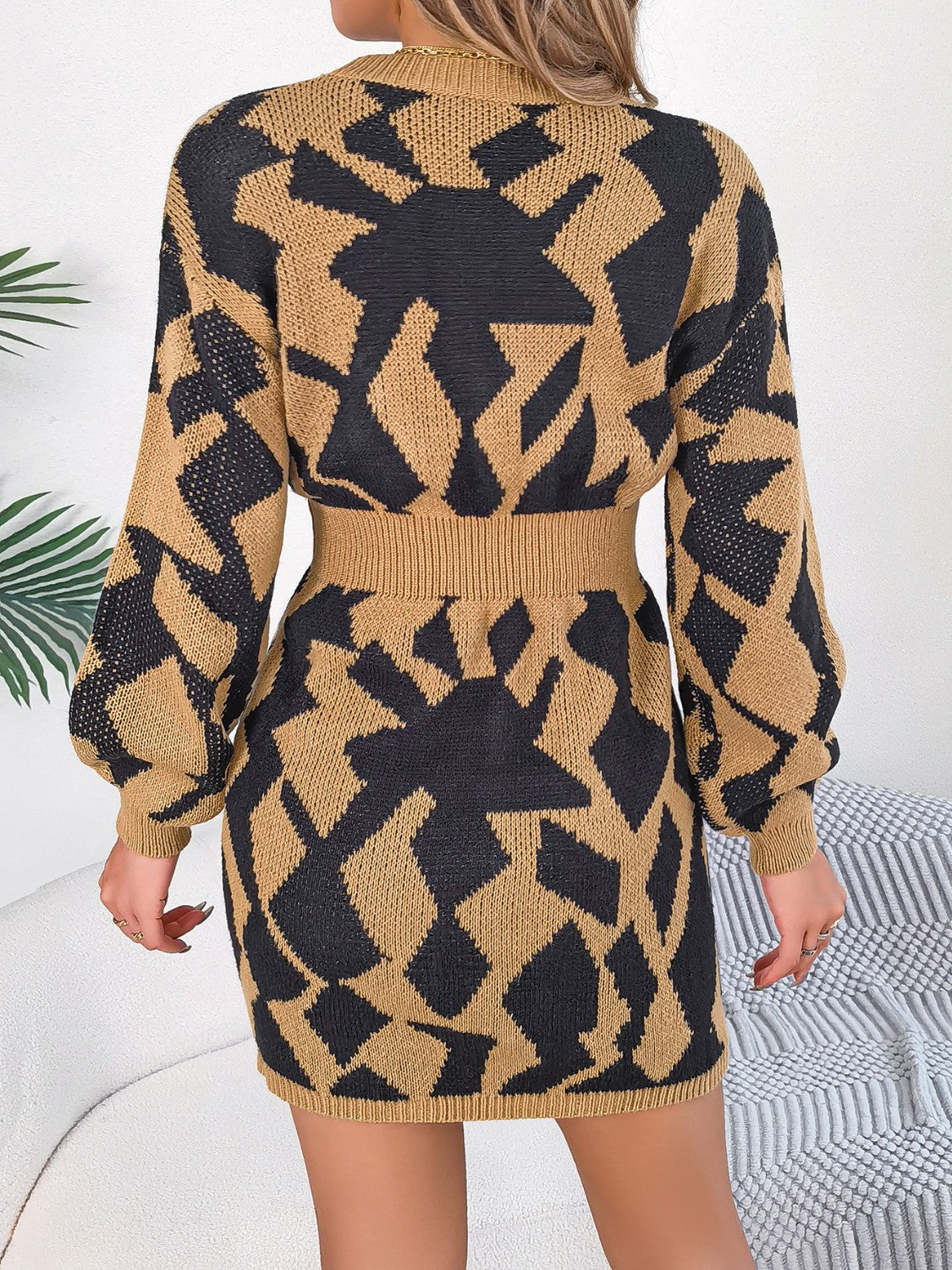Knit mini dress in khaki with black geometric pattern, long sleeves, and belted waist.