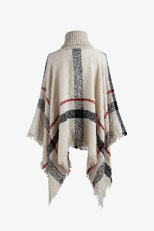 Beige plaid turtleneck cape with fringe detail and textured acrylic knit.