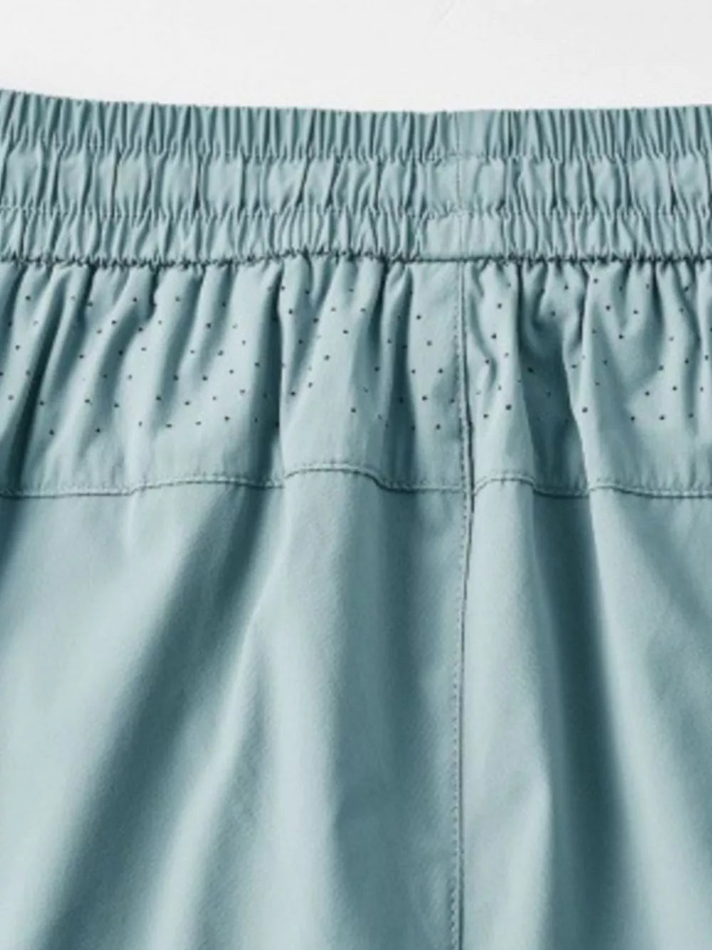 Men's turquoise drawstring active pants with elastic waistband and perforated detail.