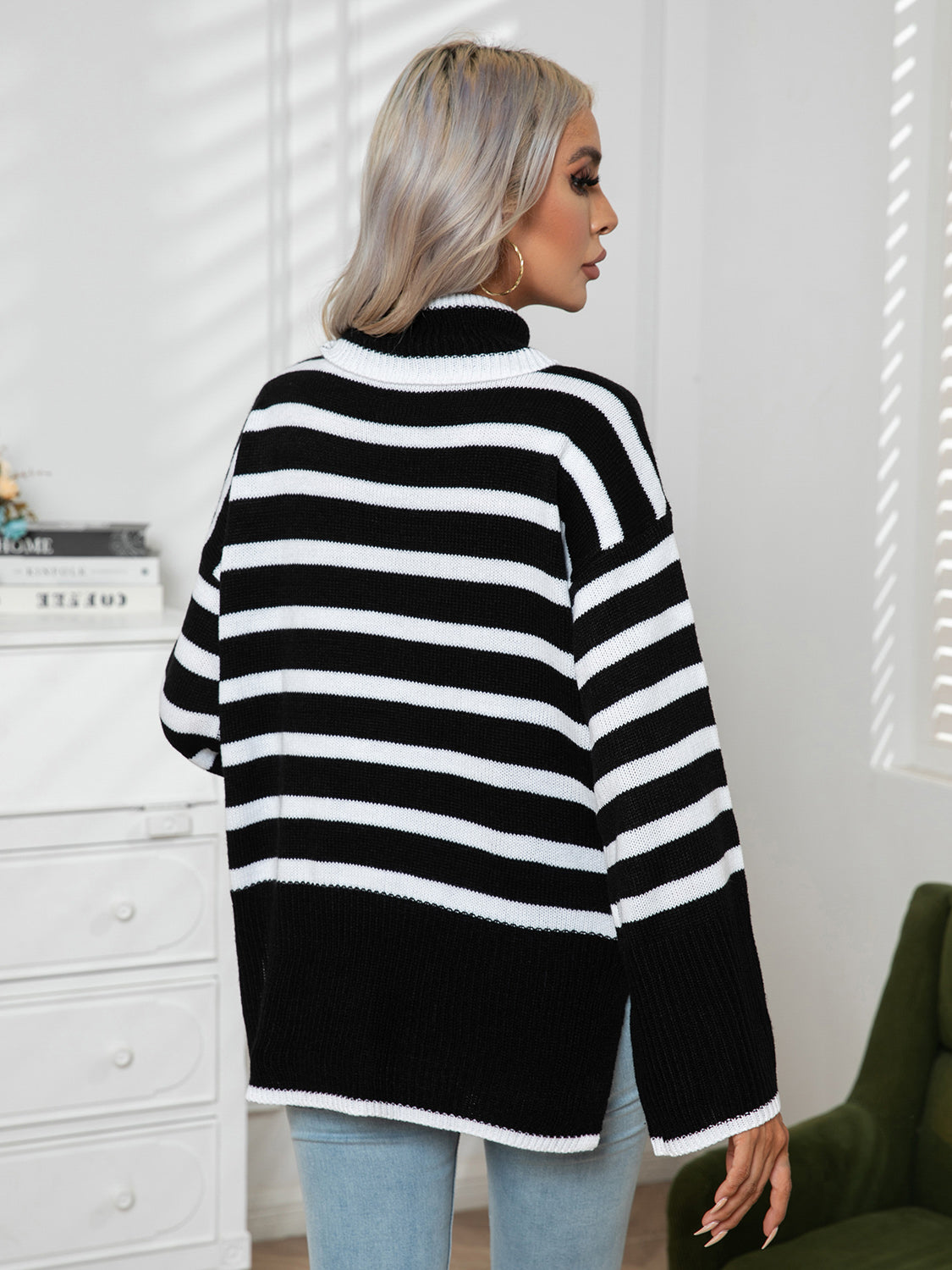 Black and white striped turtleneck sweater with flared sleeves and a relaxed fit.