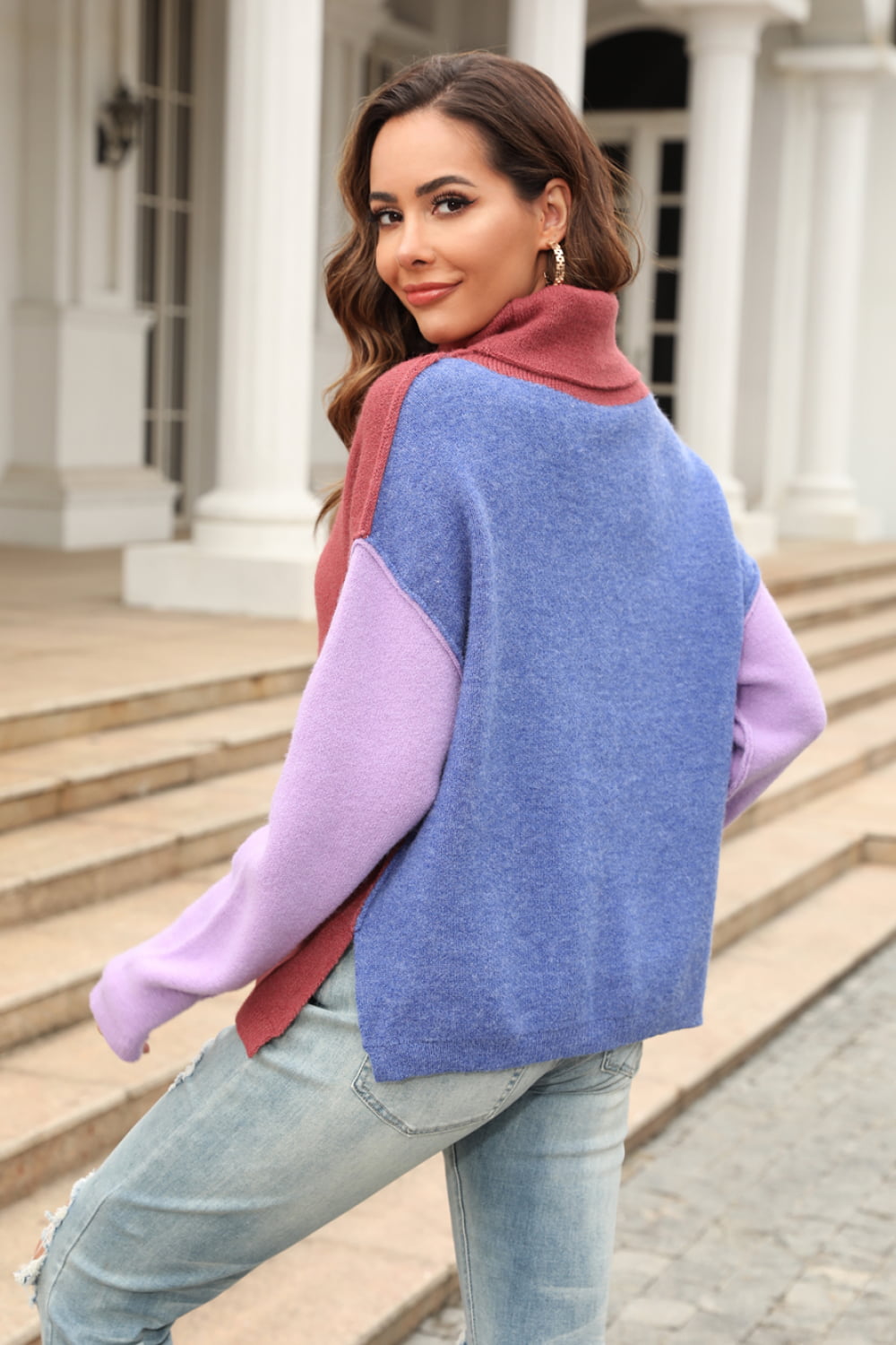 Colorblock turtleneck sweater with asymmetric hem in rust, blue, and lavender.