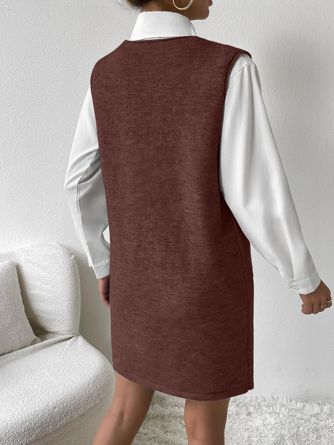 Brown knit sleeveless mini dress with pocket detail, layered over a white shirt.