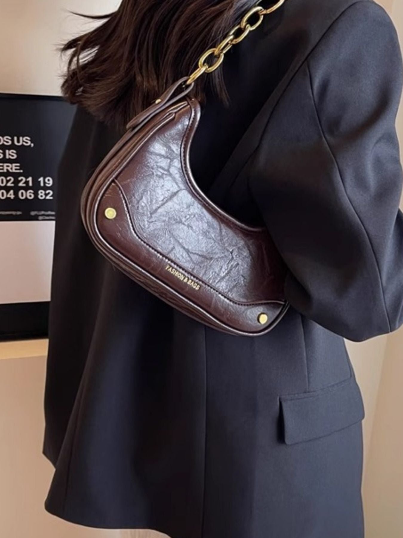 Coffee color mini shoulder bag with chunky gold chain detail and embossed logo.