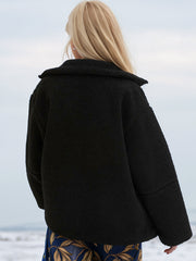 Black sherpa jacket with stand collar from behind, featuring textured fleece and relaxed fit.