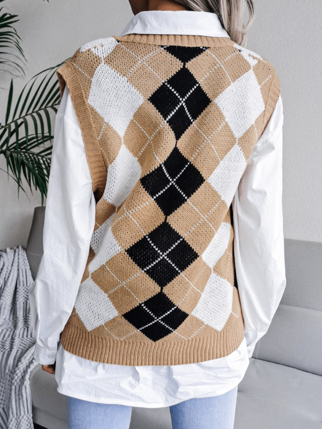 Argyle knit sweater vest in tan, black, and white acrylic, styled over a white shirt.