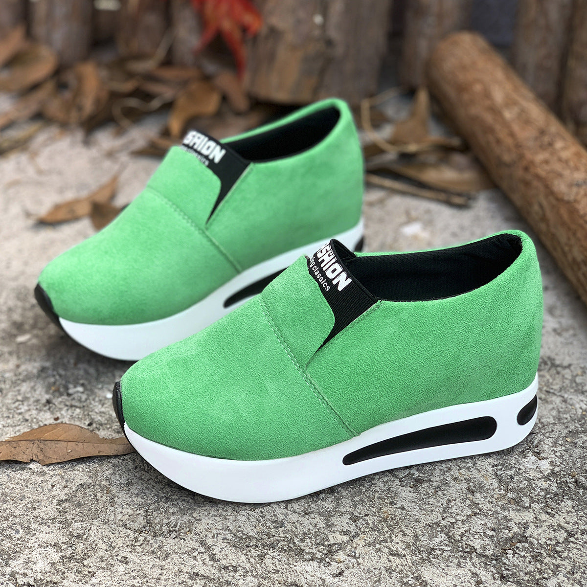 Green slip-on sneakers with a round toe and white platform sole.