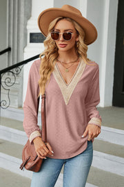 Pink textured V-neck blouse with lace trim and long sleeves