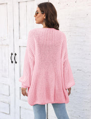 Blush pink balloon sleeve knit cardigan with ribbed texture and pearl buttons.