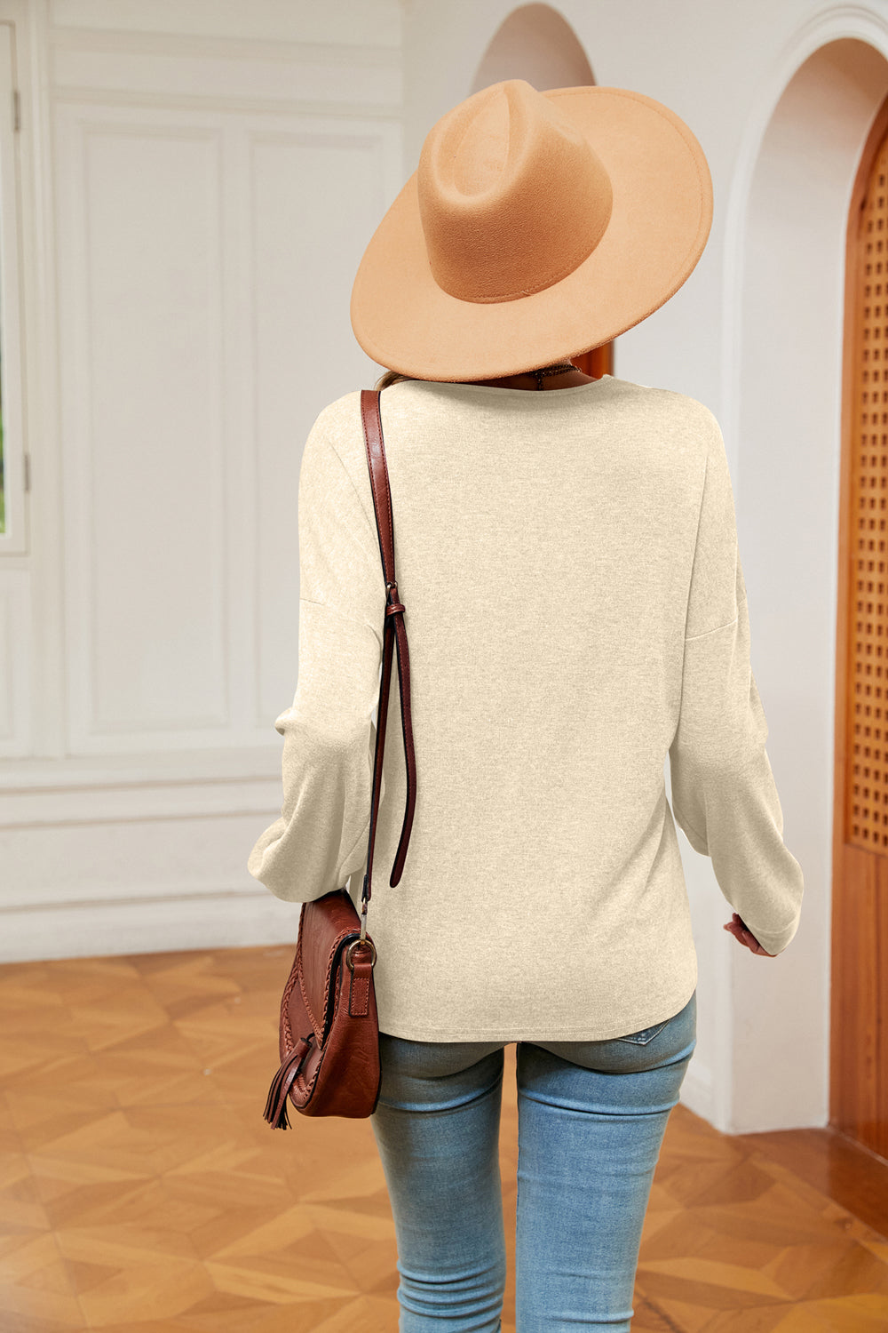 Relaxed knit sweater in pastel yellow with V-neck and lace trim detail.