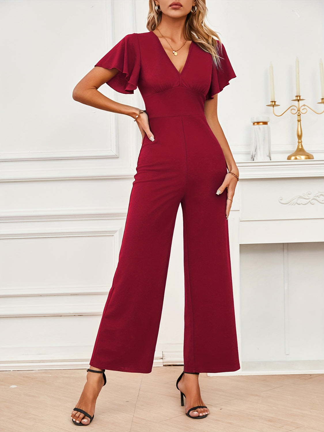 Burgundy flutter sleeve V-neck wide-leg jumpsuit with a fitted waist.