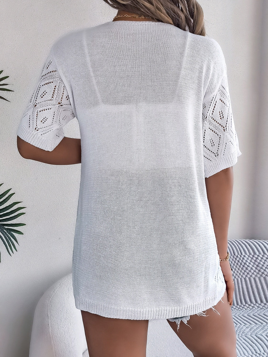 White open-knit cardigan with diamond pattern sleeves and a relaxed fit.
