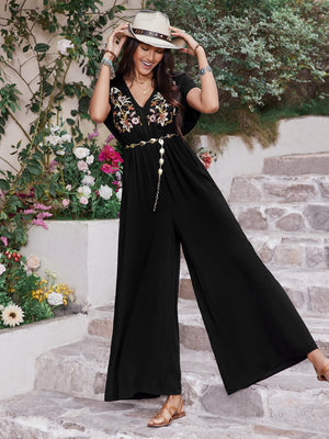 Black embroidered flutter sleeve wide-leg jumpsuit with a v-neck and chain belt.