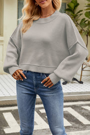Boxy ribbed knit sweater in light gray with crew neck and dropped shoulders.