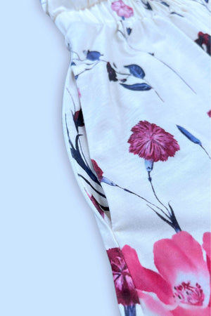 White floral print dress with elastic waist and side pocket detail.