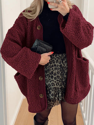 Burgundy teddy-texture button-up jacket with corduroy trim and pockets.