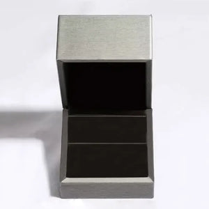 Silver ring box with open lid and dark interior.