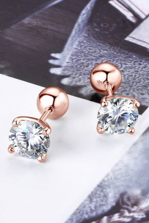 Rose gold moissanite solitaire stud earrings with a round cut diamond and sterling silver backing.