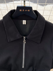 Black cotton midi dress with a collared neckline and quarter-zip closure.