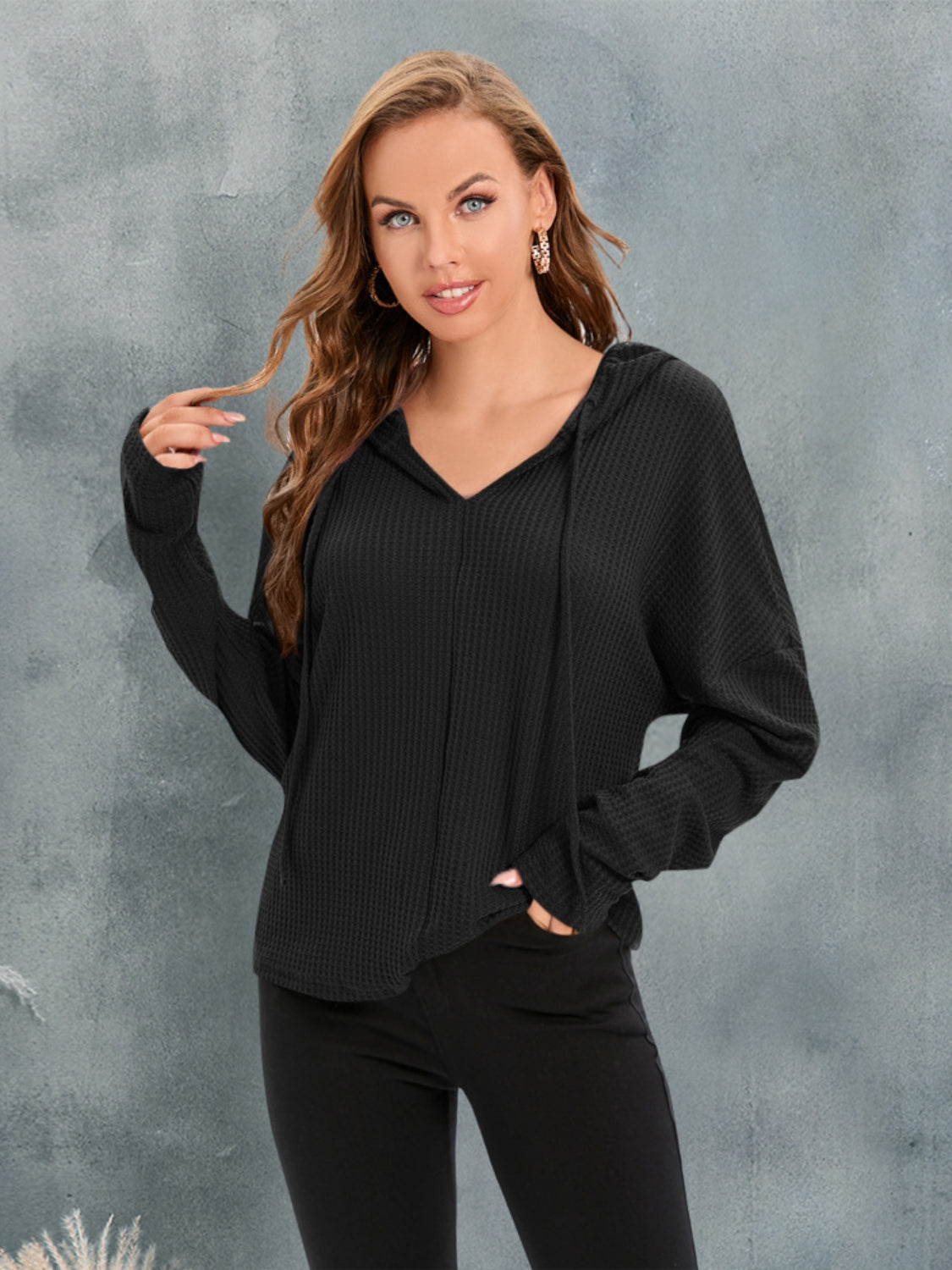 Black waffle knit relaxed fit hoodie with V-neck and drawstring.