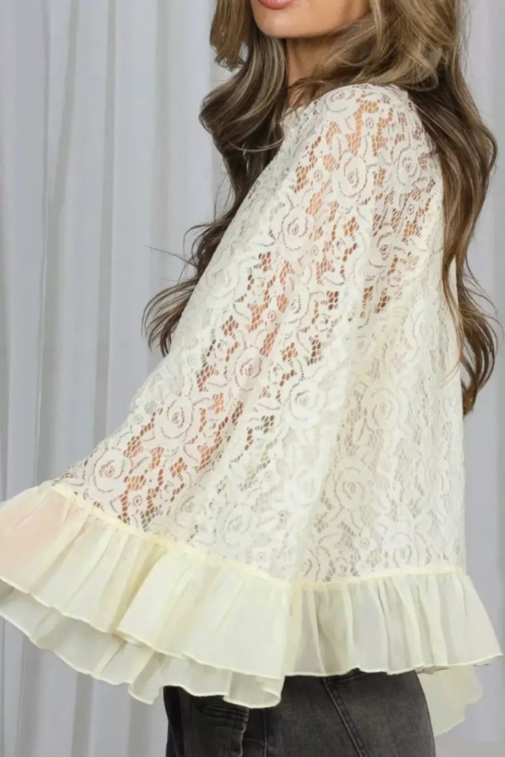 Cream floral lace maternity shirt with ruffled hem and sheer bell sleeves.