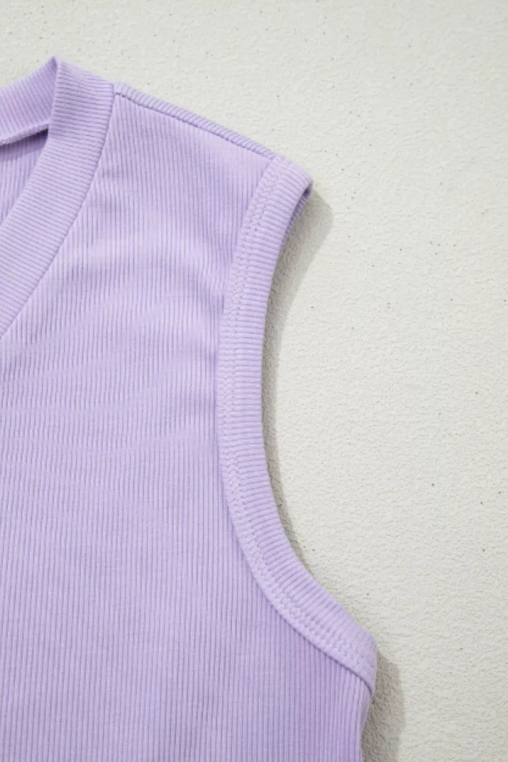 Lavender ribbed knit tank top with V-neck and sleeveless design.