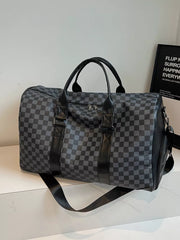 Black checkered travel bag with leather accents and shoulder strap