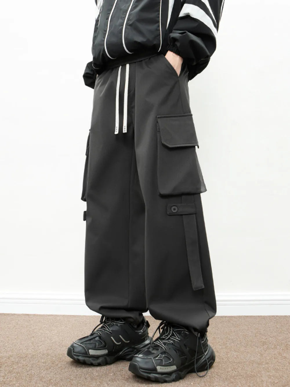 Black cargo pants with drawstring waist and multiple pockets.