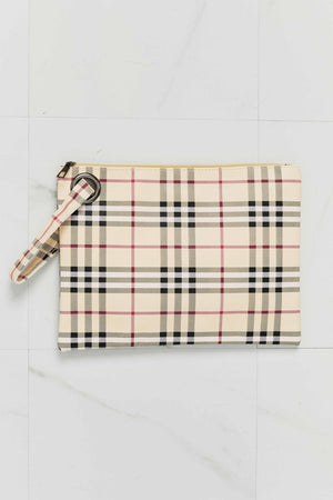 Plaid wristlet clutch bag in cream with black, red, and white lines, featuring a grommet detail and wrist strap.