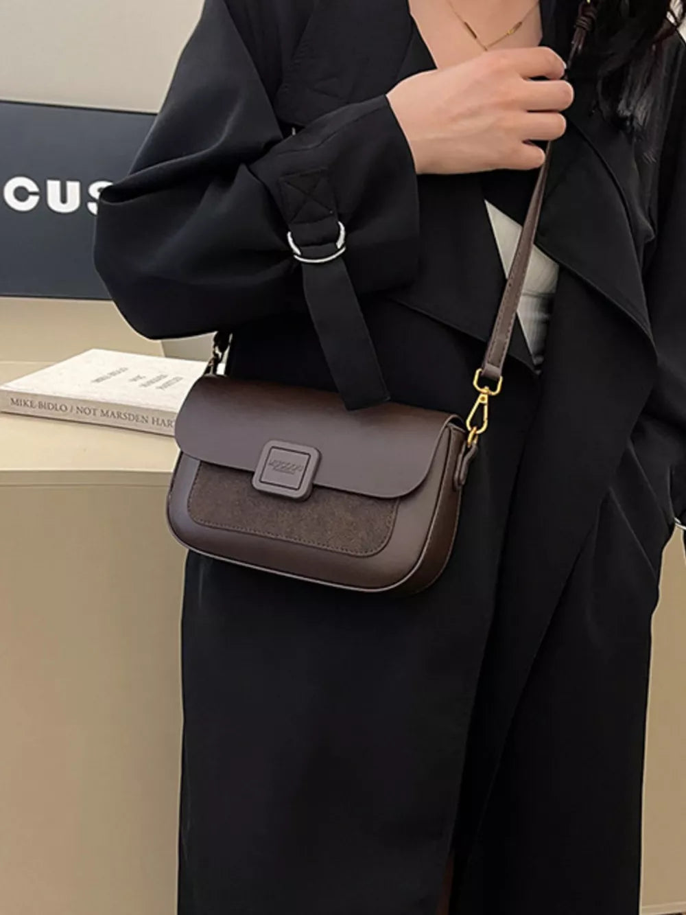 Chic two-tone crossbody bag in coffee brown with a textured panel and gold hardware.