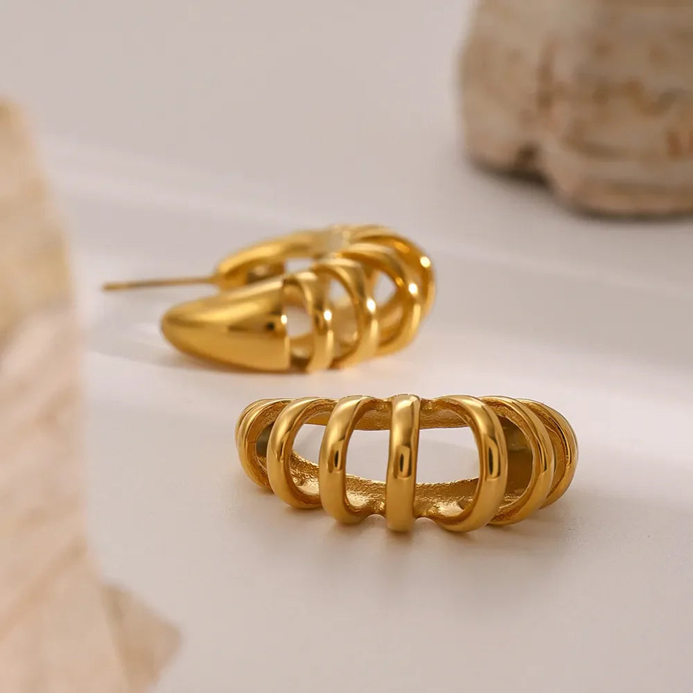 Sculptural ribbed gold hoop earrings with a modern, chic design.