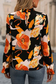 Black floral print high-neck blouse with ruffled cuffs and keyhole back detail.