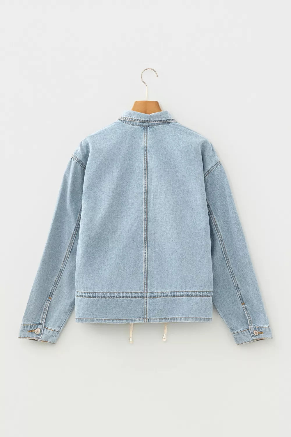 Light wash denim trucker jacket with relaxed fit and adjustable draw-cord hem.