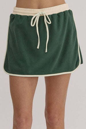 Dark green skort with cream trim and drawstring waist, part of a set.