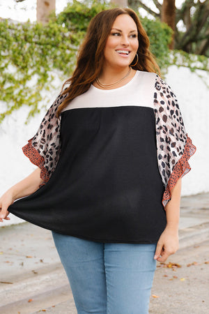 Colorblock waffle knit top with leopard print flutter sleeves and black body.