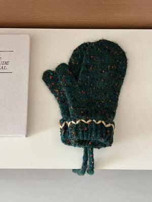 Green textured knit mittens with zig-zag detail and braided ties.