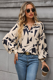 Cream geometric print blouse with voluminous sleeves and a collared neckline.
