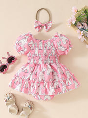 Pink bunny print baby dress with smocked bodice and ruffled hem, includes matching bow headband.