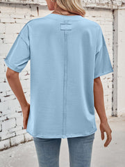 Light blue cotton oversized tee with seam detail and rolled sleeves.