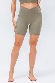 Cross-waist bike shorts in Matcha Green with side pockets and ribbed texture.